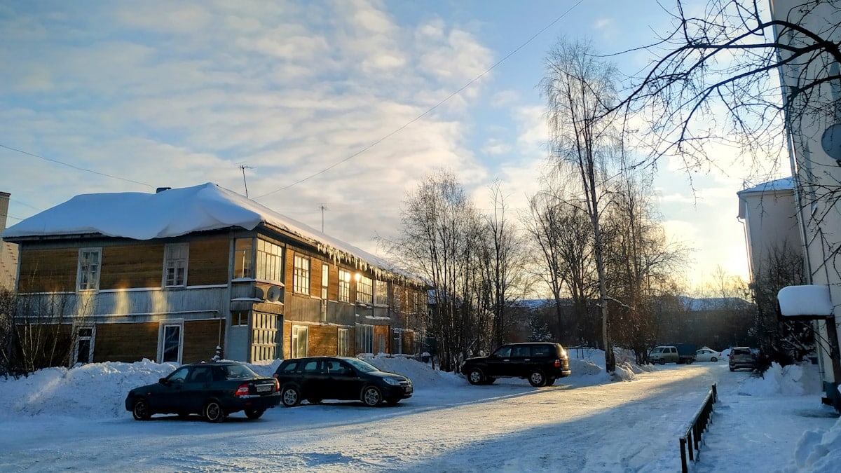 cars parked on the side of a snow covered road